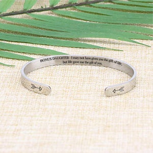 I may not have given you the gift of life but life gave me the gift of you bracelet with silver plating laying flat on a burlap surface with a leafy background
